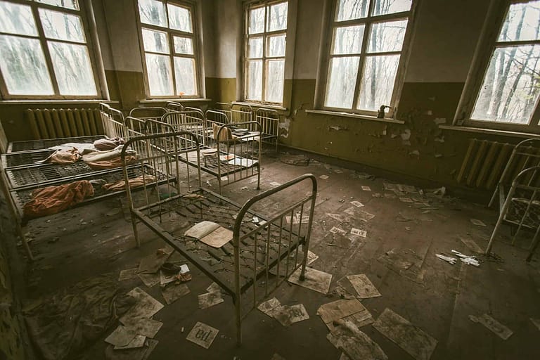 A room full of empty wire-frame beds.